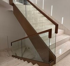 a staircase with glass railing and marble steps