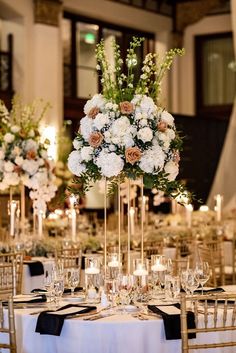 the centerpieces are filled with white flowers and greenery, along with candles