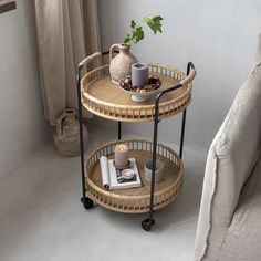 two tiered trays with plants and candles sit on a table next to a couch