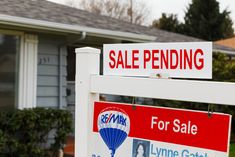 two for sale signs in front of a house