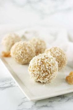 three coconut balls are on a white plate