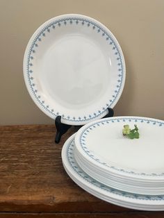 four white plates stacked on top of each other with blue and white trimmings