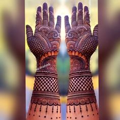 two hands with henna designs on them