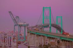 an image of a bridge that is going over the water at night time with cars driving on it