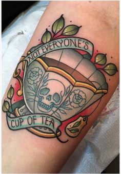 a tattoo with a skull and banner on the arm that says, not everyone's cup of tea