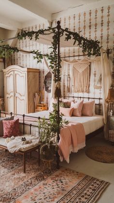 a bedroom with a canopy bed, rugs and plants on the floor next to it