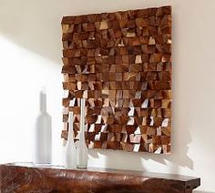 a large piece of wood sitting on top of a table next to a white vase