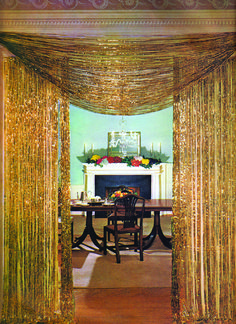 an elegant dining room with gold drapes on the ceiling and fireplace in the background