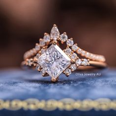 an engagement ring with a princess cut diamond surrounded by smaller diamonds