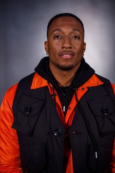 a man in an orange and black jacket