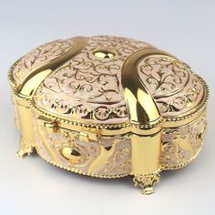 an ornately decorated gold jewelry box on a white background