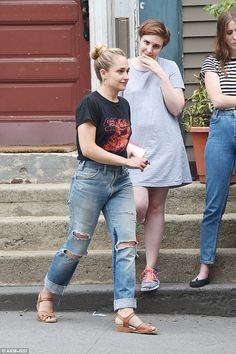 two young women are walking down the street