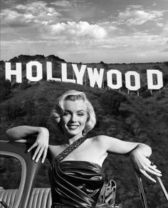 marilyn monroe posing in front of the hollywood sign