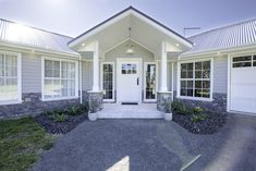 a house with white doors and windows in the front yard