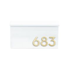 a white house number sign with gold numbers