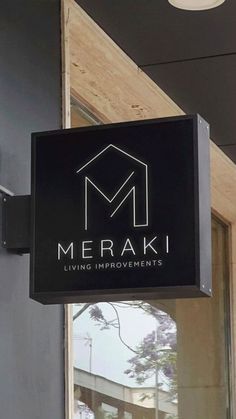 a sign hanging from the side of a building that says merak living improvements on it