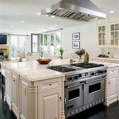 a kitchen with an oven, stove and sink in it's center island area