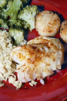 a red plate topped with chicken, broccoli and rice