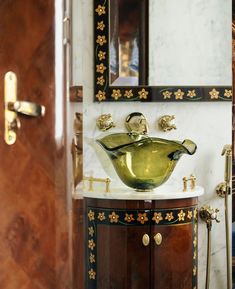 a bathroom sink sitting under a mirror next to a wooden cabinet