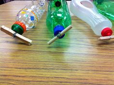 three plastic bottles sitting on top of a wooden table next to toothbrushes and toothpaste