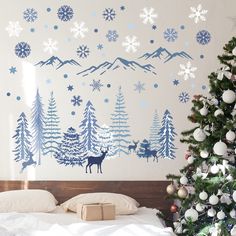 a bedroom decorated for christmas with snowflakes on the wall and deer in the trees