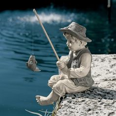 a statue of a boy fishing with a fish