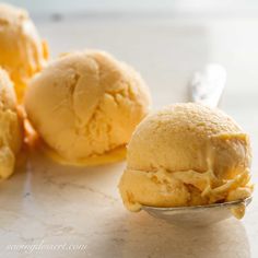 two scoops of ice cream sitting on top of a table next to each other