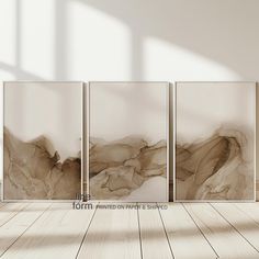 an empty room with three paintings on the wall and one in the foreground that has a wooden floor