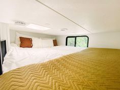 a bed in a room with yellow sheets and pillows