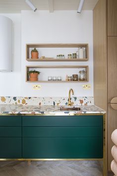 the instagram page shows an image of a kitchen with green cabinets and gold faucets