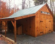 a wooden building with a metal roof in the middle of some leaves on the ground