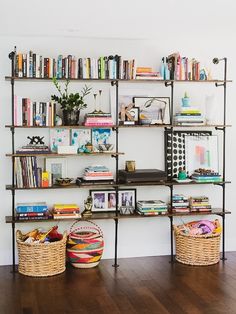 the bookshelf is filled with many books and baskets on it's sides