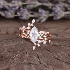 a close up of a ring on a piece of wood with flowers in the background