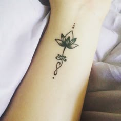 a woman's arm with a flower tattoo on the left side of her wrist