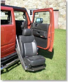 two red trucks parked next to each other in the grass with their doors open and seats up