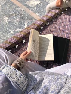 a person sitting on the floor reading a book