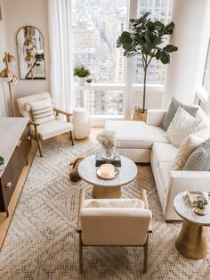 a living room with couches, chairs and tables in front of a large window