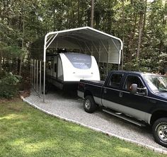 a truck with a camper attached to it parked in front of some trees and grass