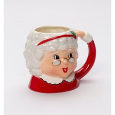 a ceramic mug with a santa clause on it's head and glasses in front of a white background