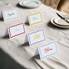 place cards on a table with plates and silverware