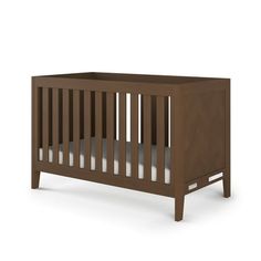 a wooden crib with white sheets on the bottom