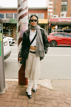 a woman standing next to a pole with a scarf around her neck