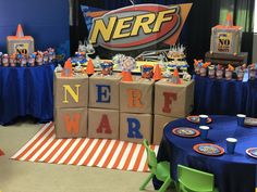 a nerf themed party with blue tablecloths and orange napkins on it