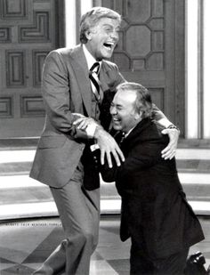 two men in suits and ties are hugging each other on the set of tv show