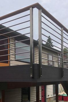 a dog is standing on the front porch of a house that has a metal railing