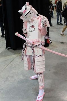 a person dressed in pink and white holding a stick