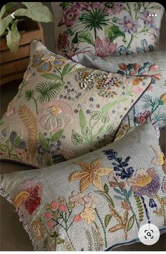 three decorative pillows with flowers on them