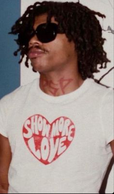 a man with sunglasses on his head wearing a t - shirt that says show me love