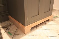 an unfinished kitchen cabinet in the process of being painted and sealed with plastic wrap on the floor