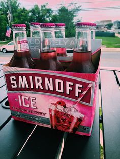 six bottles of smirnoff ice sit on a picnic table